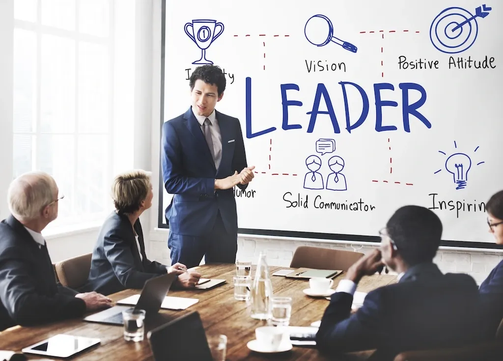 Some people in a meeting with leader written in the board
