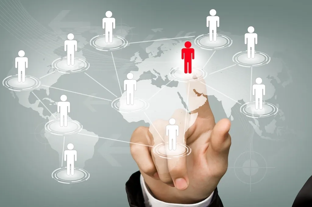 A businessman selecting a human pin that is interconnected with other pins around the world