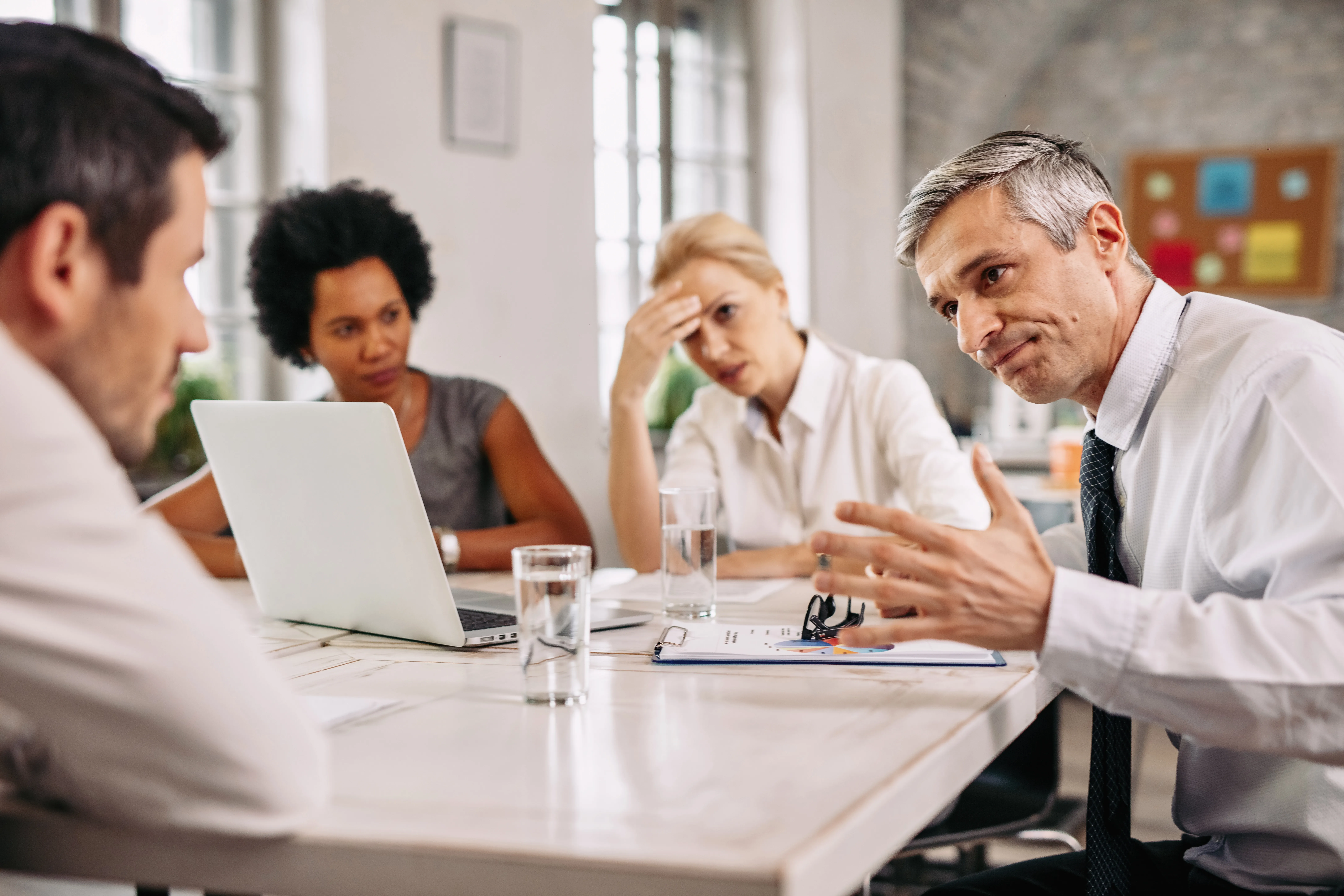 angry-businessman-discussing-with-colleague-meeting-office.webp