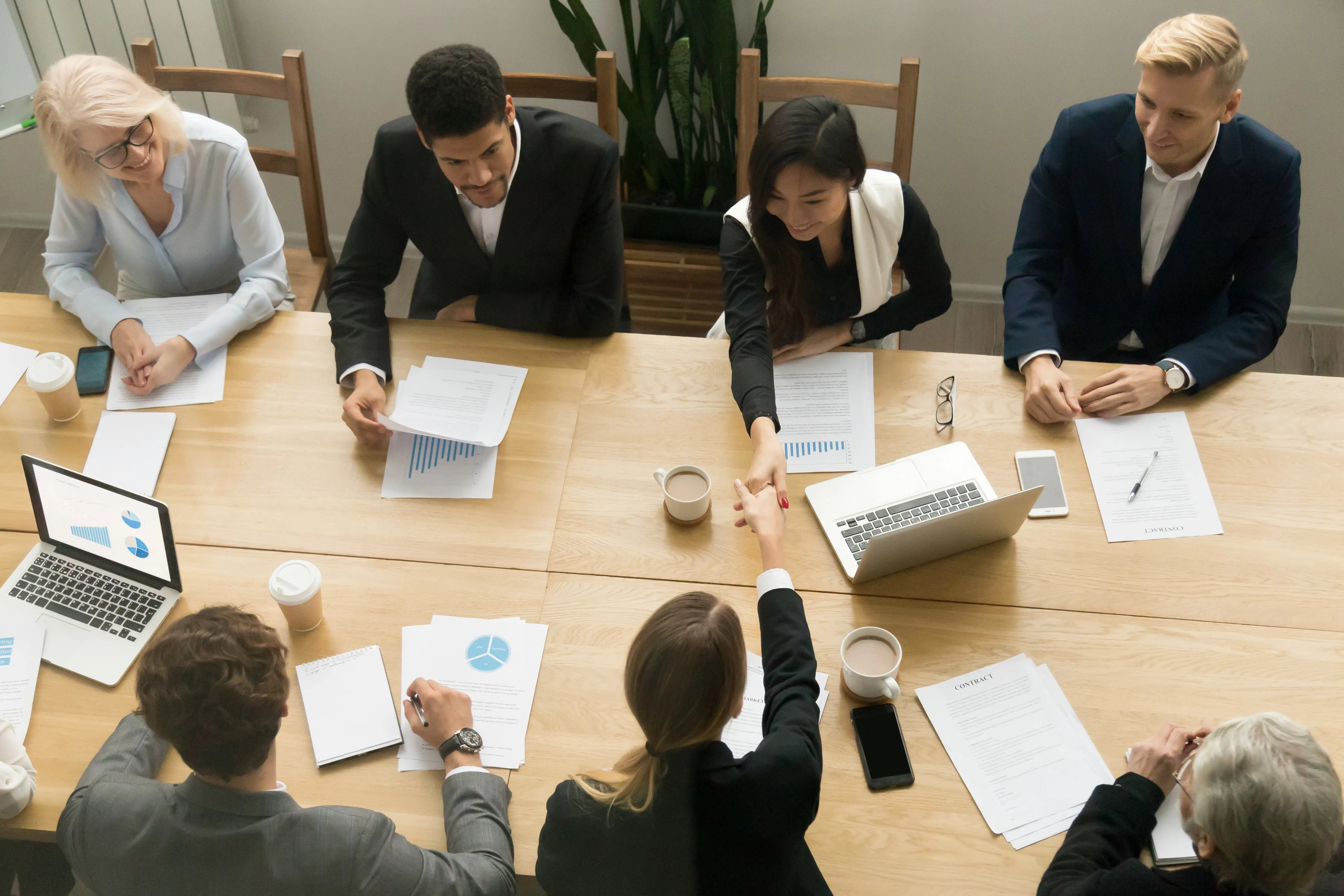 asian-caucasian-businesswomen-handshaking-group-meeting-top-view.webp