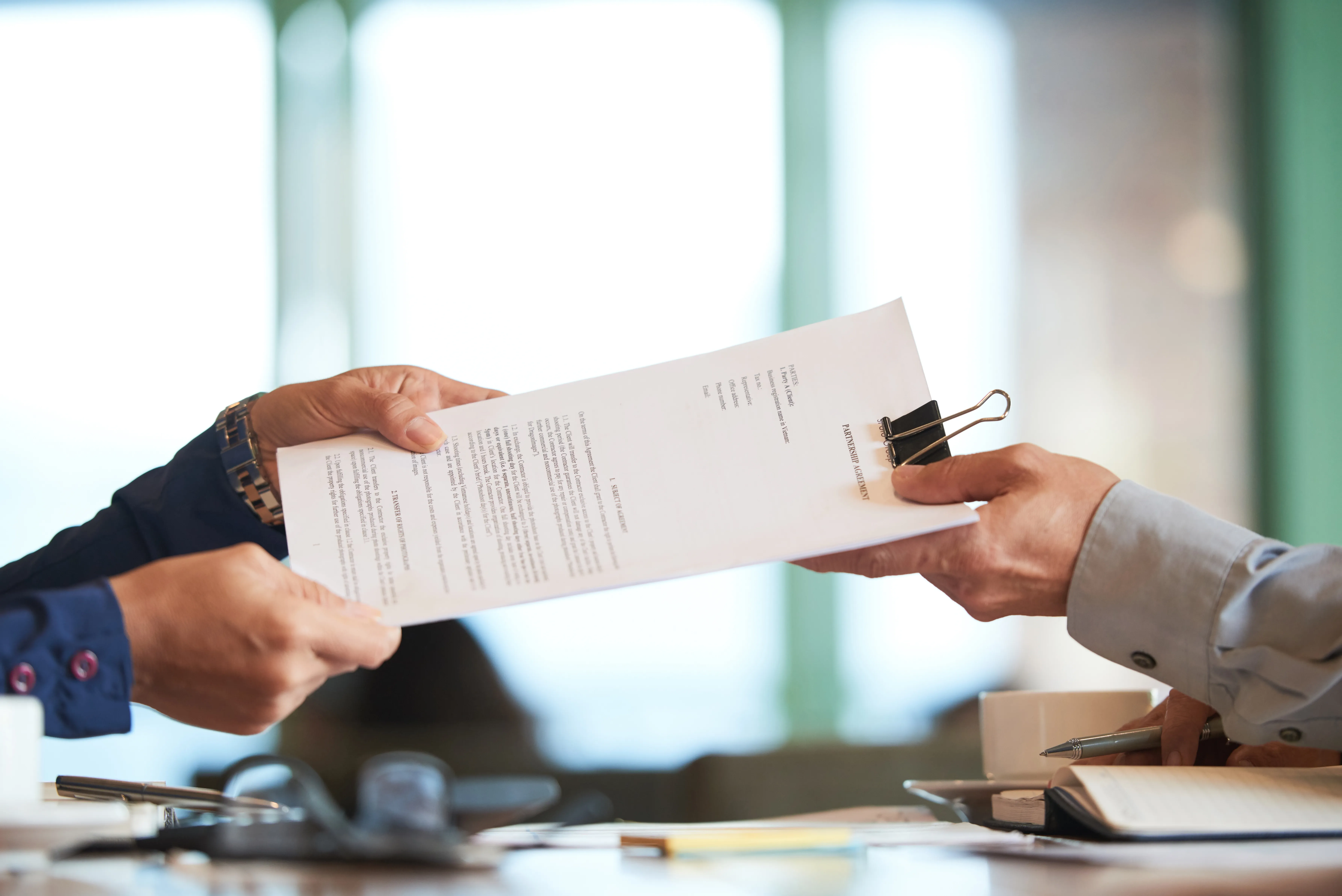 closeup-hands-passing-contract-unrecognizable-businessman.webp