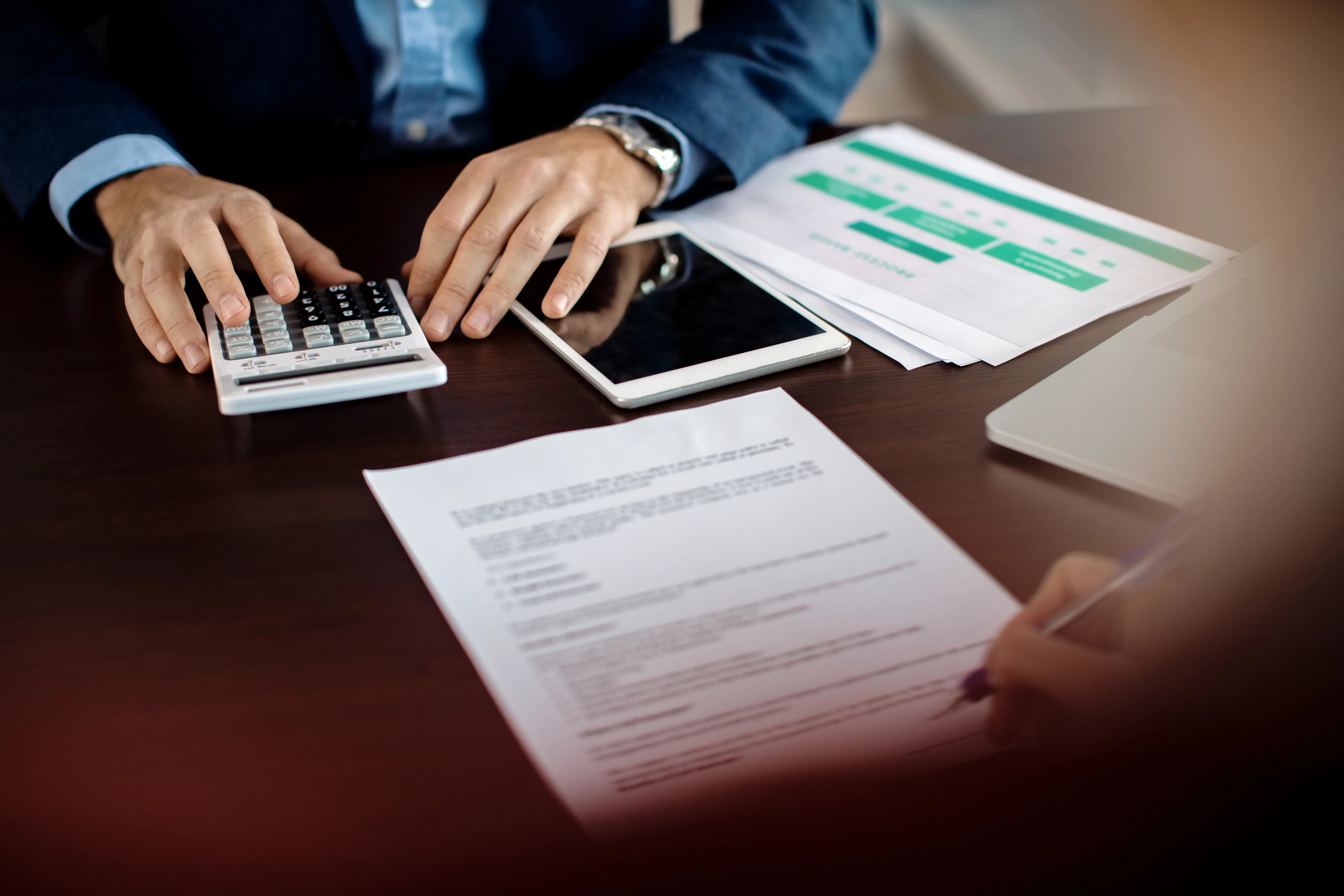 closeup-insurance-agent-making-calculations-while-signing-agreement-with-client-office.webp