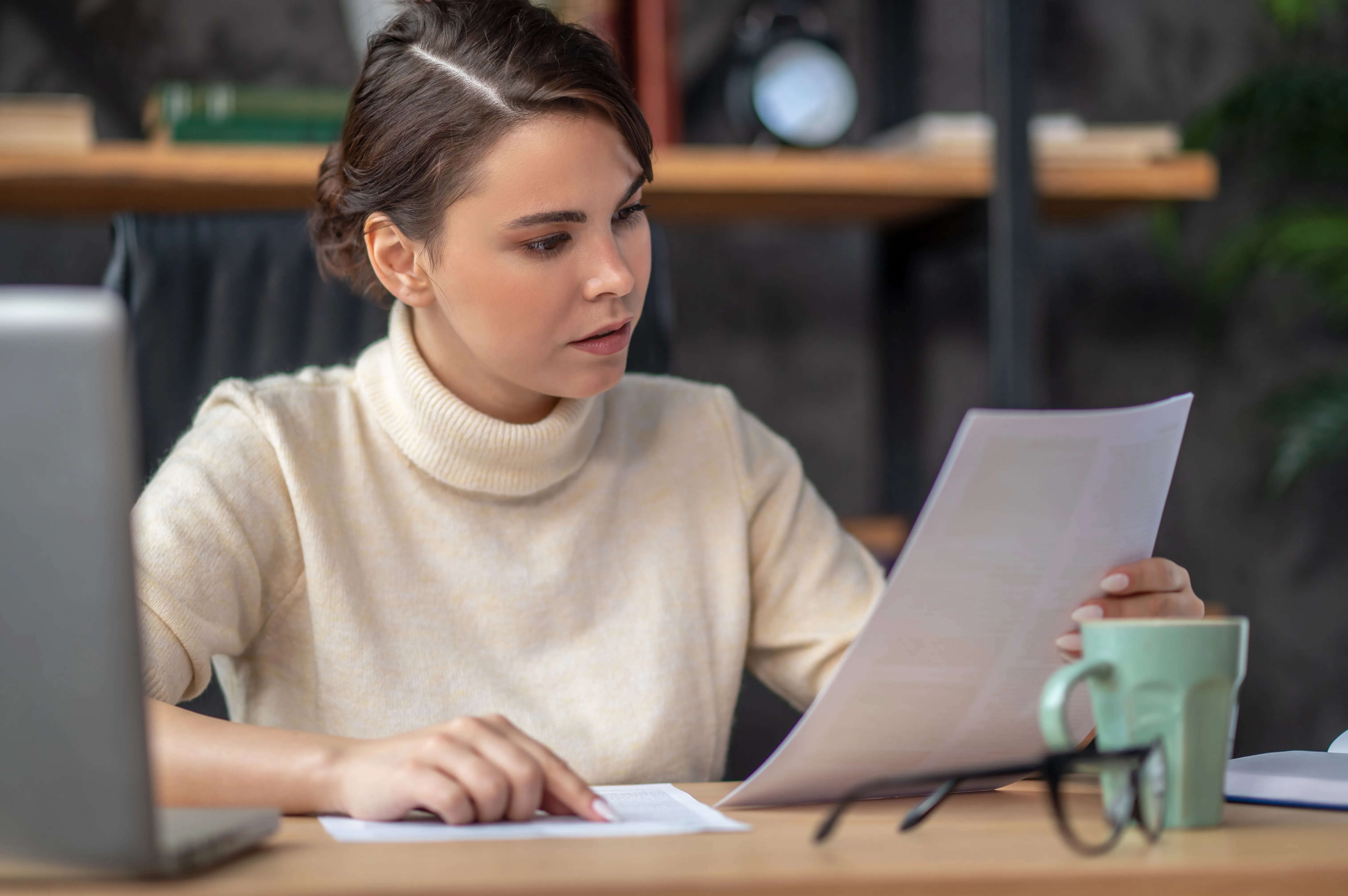 concentrated-lady-examining-documentation-desk.webp