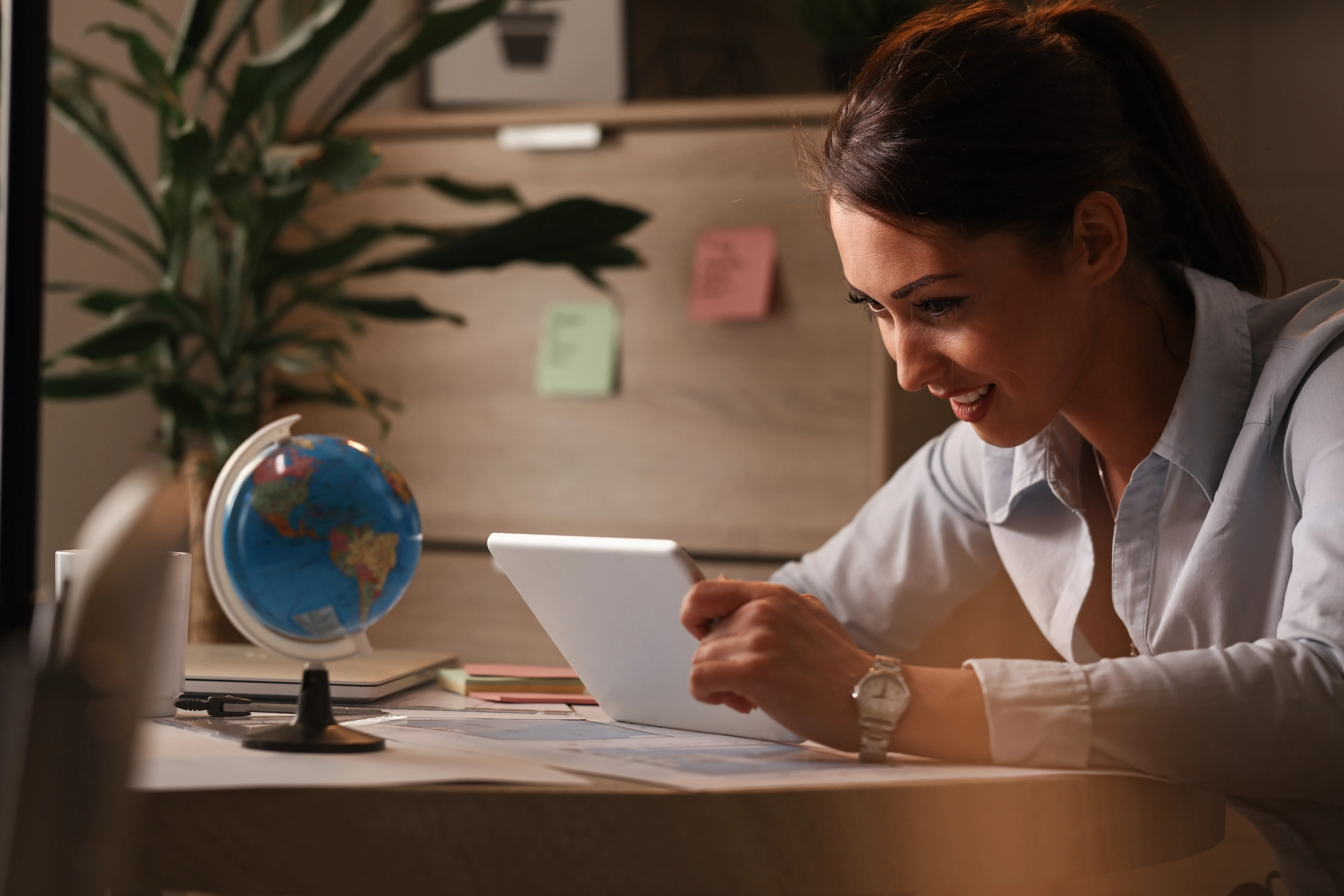 smiling-entrepreneur-going-through-business-reports-digital-tablet-while-working-office.webp