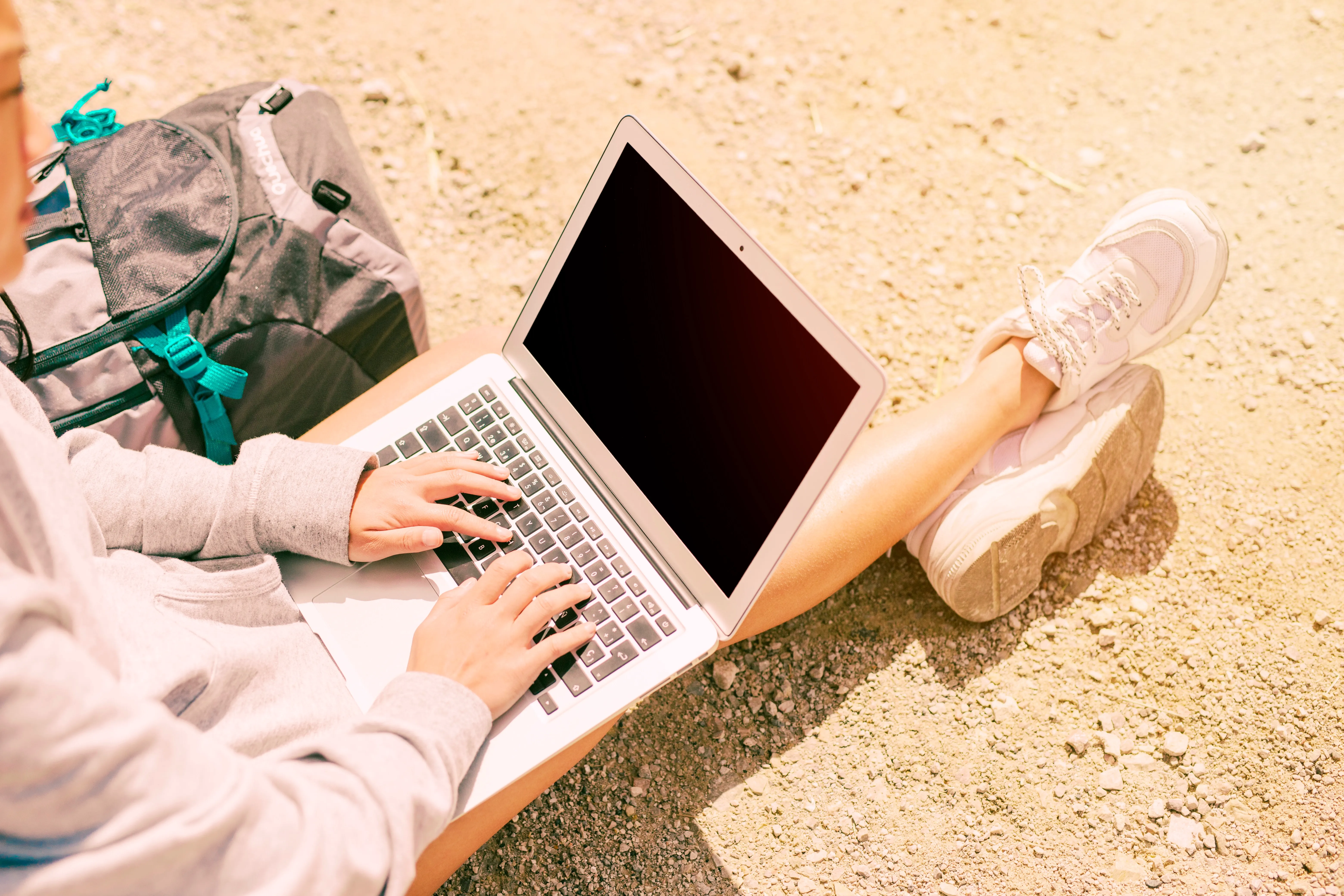 woman-sitting-ground-working-laptop.webp